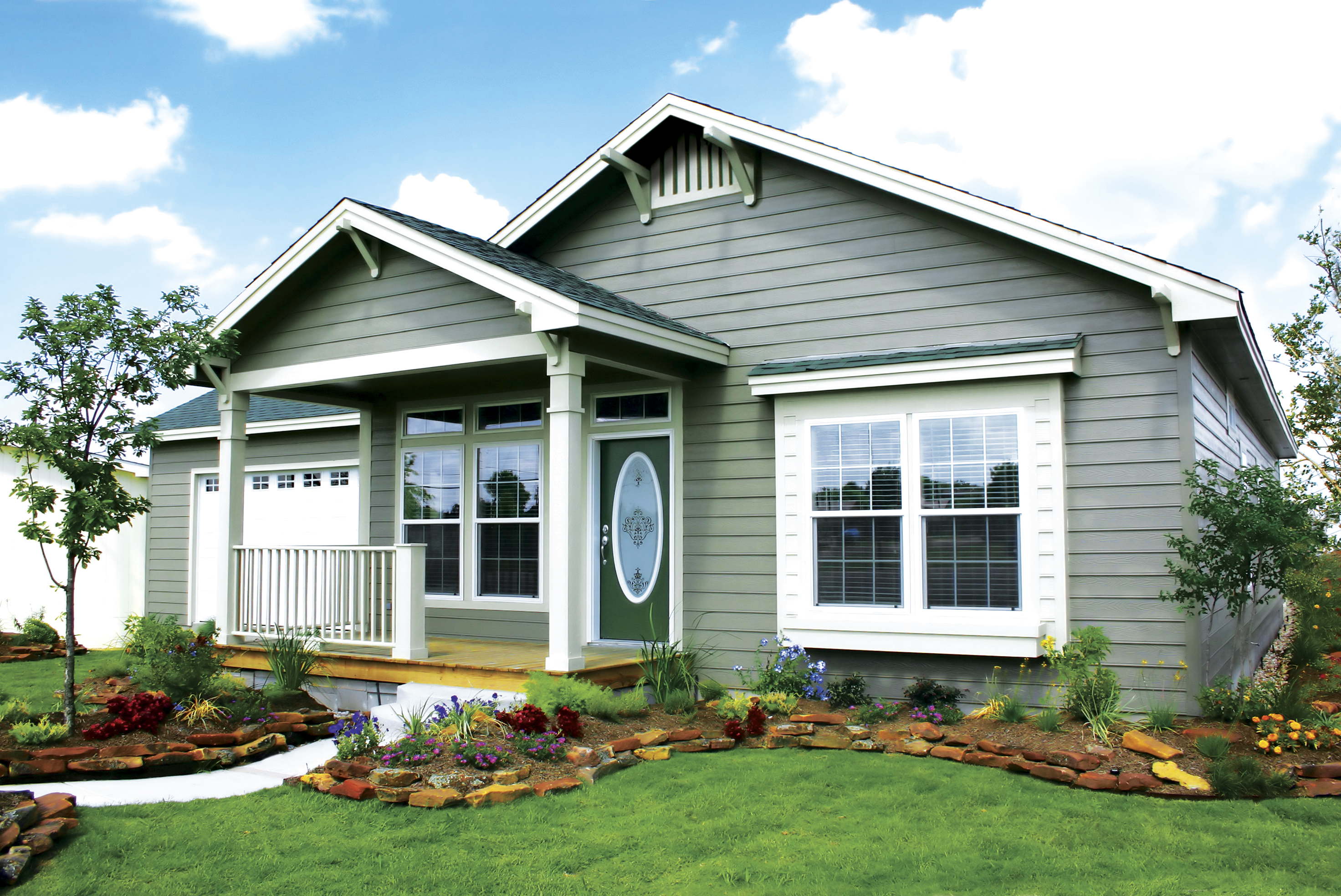 gray manufactured home with porch and garage