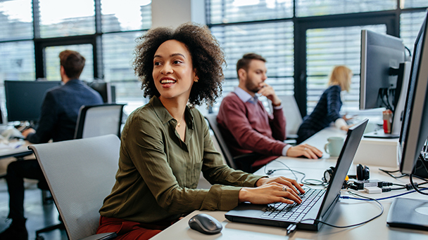 Woman looking away from laptop while at work