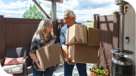 two older people moving boxes