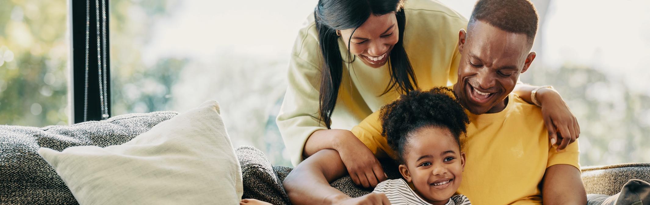 Family reading and laughing on a sofa